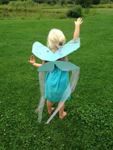 happy child that has learnt how to make fairy wings from cardboard