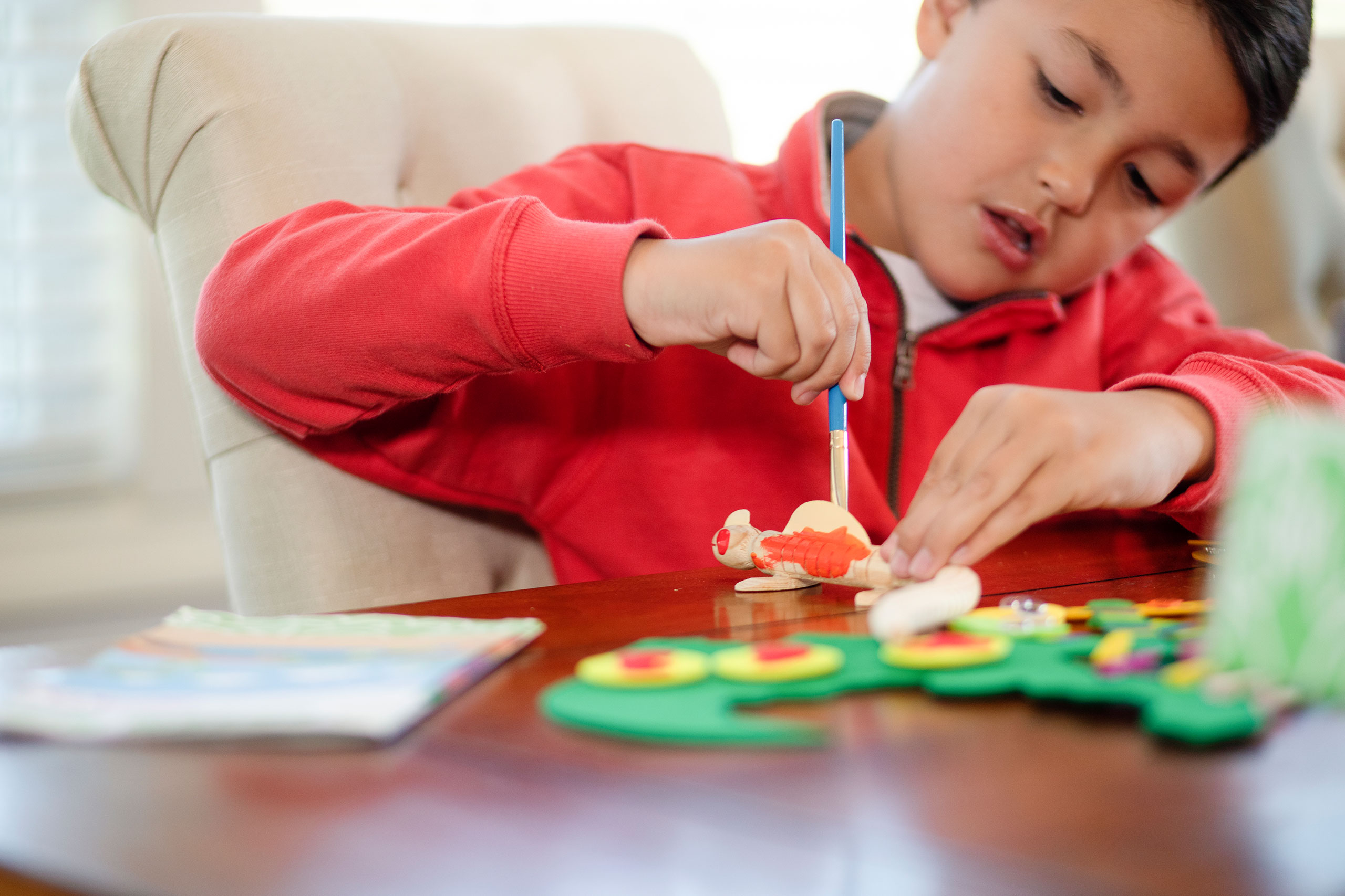 child playing with dinosaur crafting kit